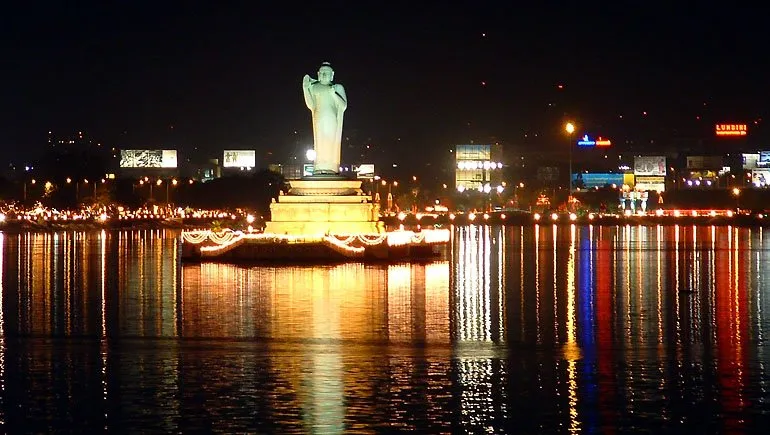Hussain Sagar Lake lit up at night, with the Buddha statue on its monolith